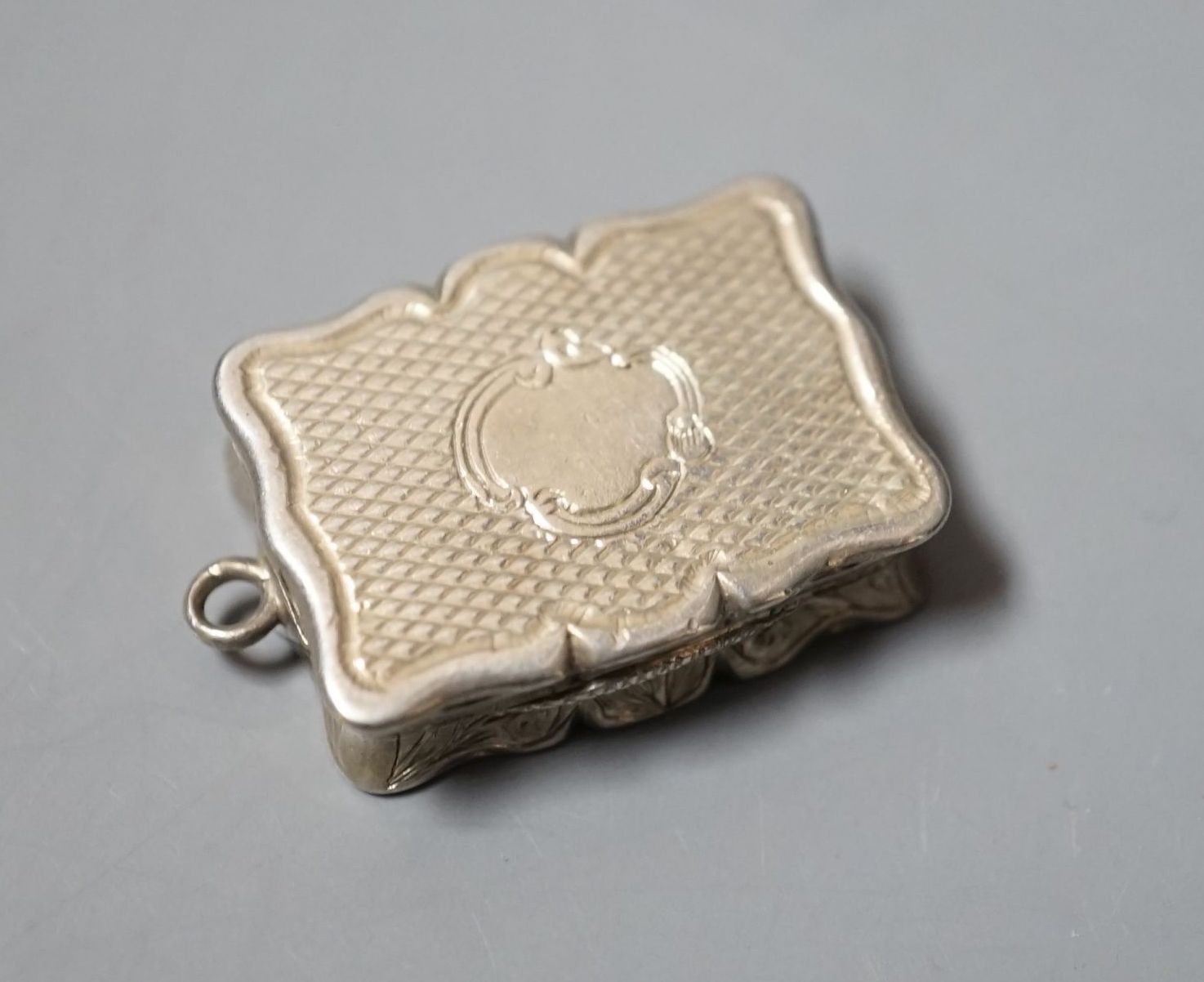 A Victorian engraved silver shaped rectangular vinaigrette, Edward Smith, Birmingham, 1847, 27mm.